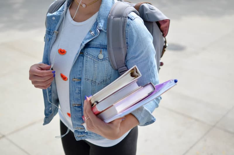 Enfant allant à l'école tenant des livres et des cahiers